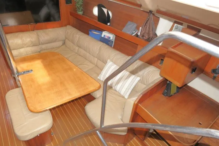 Slide: The Image of Interior of 1999 Hunter 450 Passage yacht with wooden table and beige seating. - 8