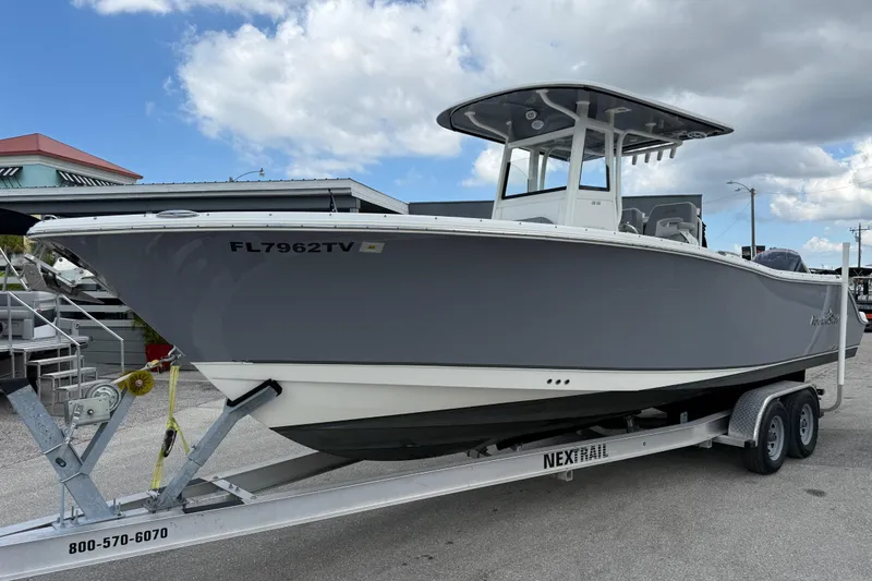 The Image of 2021 NauticStar 28 XS Offshore boat on trailer under blue sky. - 1