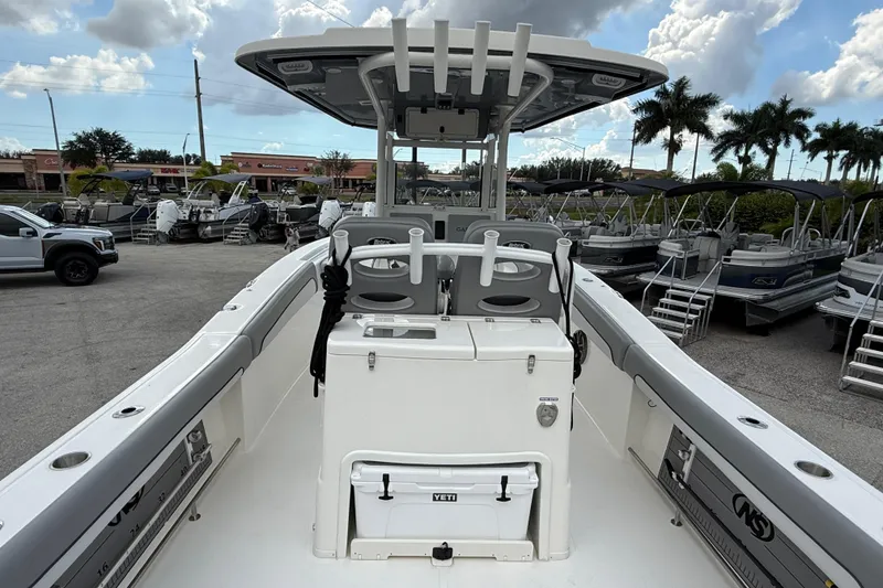 Slide: The Image of 2021 NauticStar 28 XS Offshore boat interior with fishing rod holders and Yeti cooler. - 10