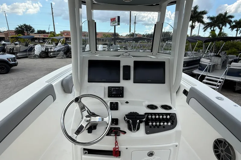Slide: The Image of 2021 NauticStar 28 XS Offshore boat dashboard with steering wheel and control panel. - 12