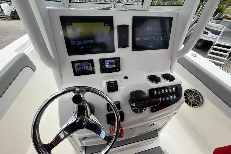 Slide: The Image of 2021 NauticStar 28 XS Offshore boat dashboard with steering wheel and electronic displays. - 17