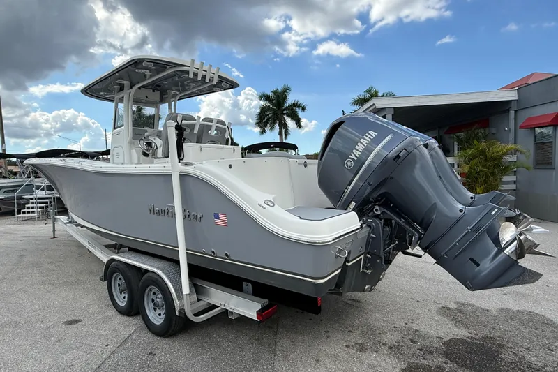 Slide: The Image of 2021 NauticStar 28 XS Offshore boat with Yamaha engine on trailer, under cloudy sky. - 9