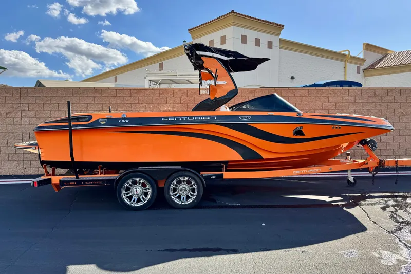 The Image of 2015 Centurion Enzo FS33 boat in vibrant orange on a trailer, parked outdoors. - 0