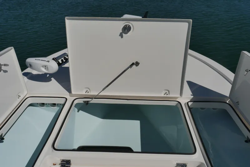 Slide: The Image of 2023 Sea Born FX24 Bay boat with open storage compartments on deck. - 10