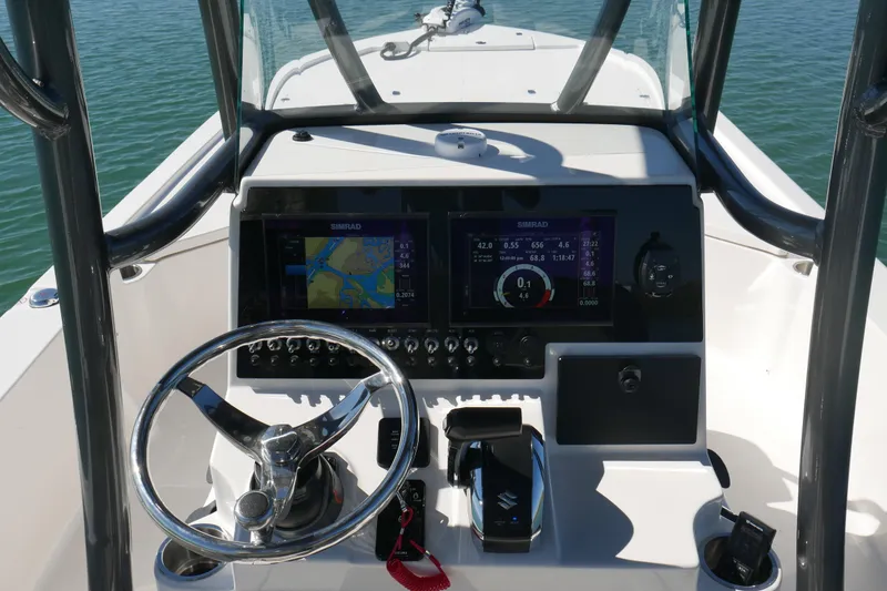Slide: The Image of 2023 Sea Born FX24 Bay boat dashboard with steering wheel and navigation screens. - 16