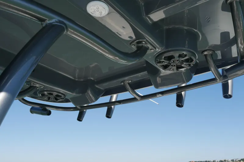 Slide: The Image of 2023 Sea Born FX24 Bay boat's underside with speakers and rod holders against blue sky. - 21