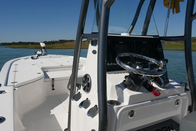 Slide: The Image of 2023 Sea Born FX24 Bay boat with sleek console and steering, cruising on calm waters. - 29