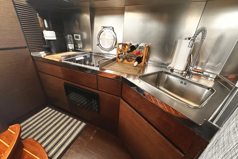 Slide: The Image of Luxurious 2007 Azimut 43S yacht kitchen with modern stainless steel appliances and elegant wood cabinetry. - 24