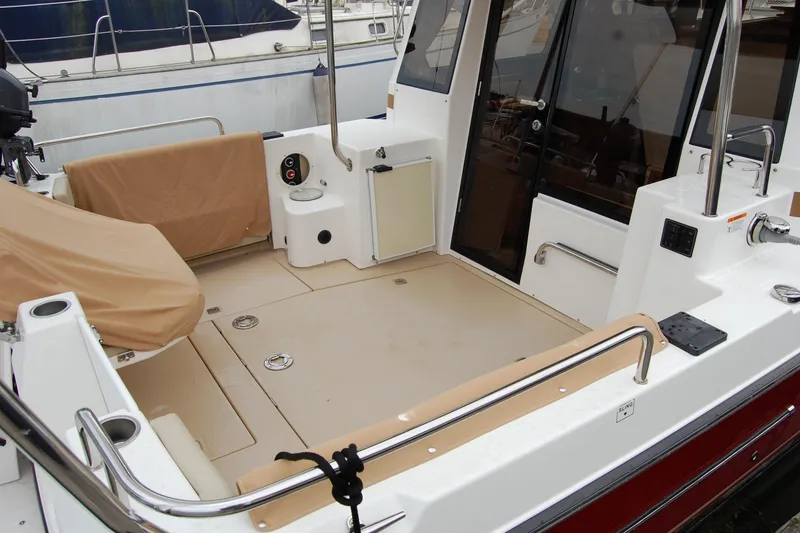 Slide: The Image of 2018 Ranger Tugs R29 boat deck with seating and railing in a marina. - 10