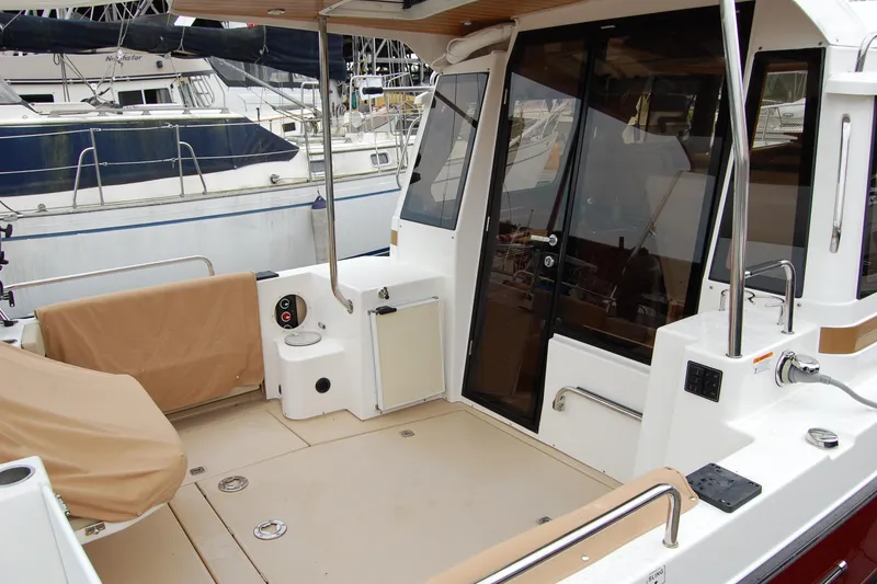 Slide: The Image of 2018 Ranger Tugs R29 boat deck with covered seating and glass doors. - 11