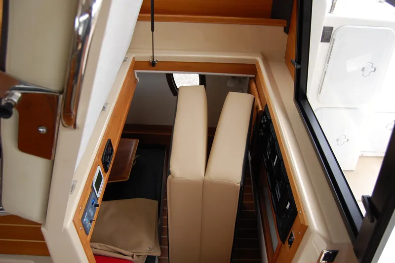 Slide: The Image of Interior view of 2018 Ranger Tugs R29 boat, featuring beige seating and control panels. - 17