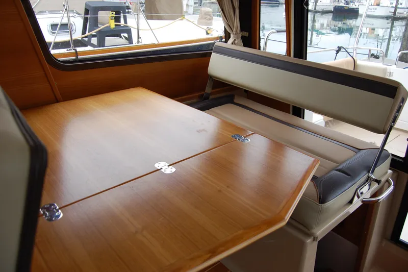 Slide: The Image of Interior of 2018 Ranger Tugs R29 with wooden table and cushioned seating. - 18