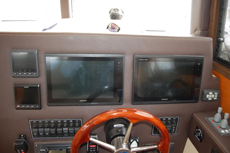 Slide: The Image of 2018 Ranger Tugs R29 helm with Garmin displays and wooden steering wheel. - 23