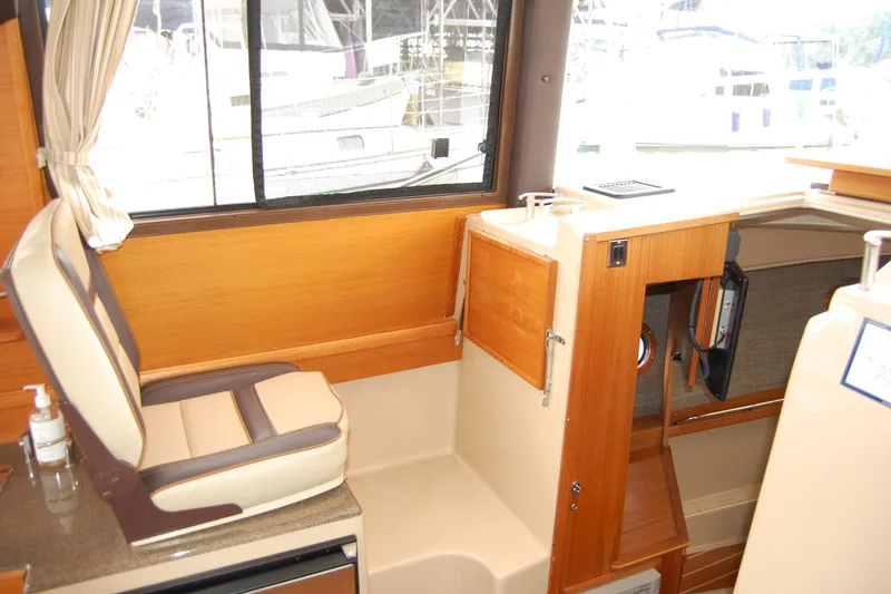 Slide: The Image of Interior of 2018 Ranger Tugs R29 boat, featuring seating and wooden cabinetry. - 25