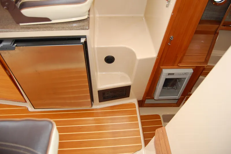 Slide: The Image of Interior of 2018 Ranger Tugs R29 with wood flooring and compact kitchen appliances. - 26