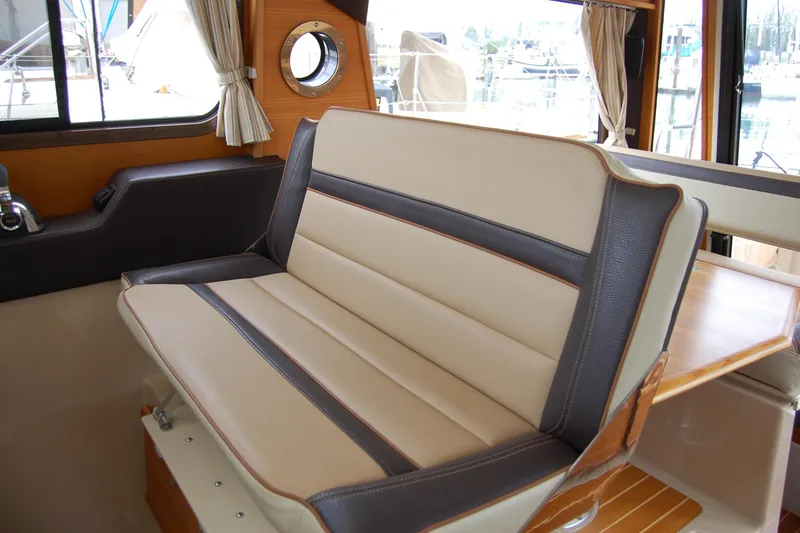 Slide: The Image of 2018 Ranger Tugs R29 interior seating with beige and brown upholstery. - 29