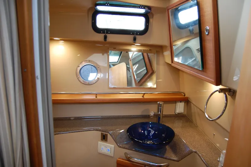Slide: The Image of 2018 Ranger Tugs R29 bathroom with modern sink, mirror, and porthole window. - 32