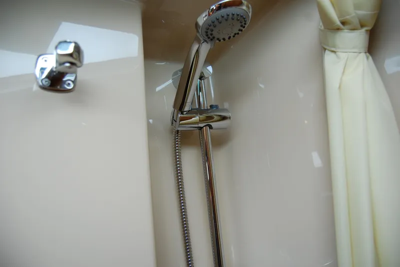 Slide: The Image of Shower area in 2018 Ranger Tugs R29 boat, featuring chrome fixtures and cream curtain. - 33