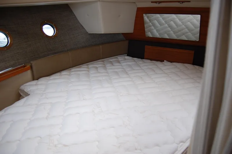 Slide: The Image of Cozy cabin interior of 2018 Ranger Tugs R29 with quilted bedding and porthole windows. - 35