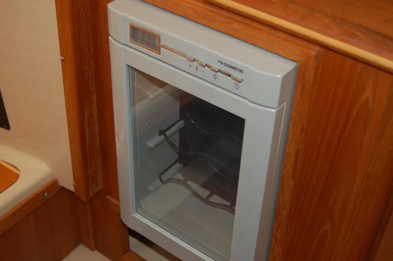 Slide: The Image of Dometic fridge inside 2018 Ranger Tugs R29 boat, featuring wooden cabinetry. - 36
