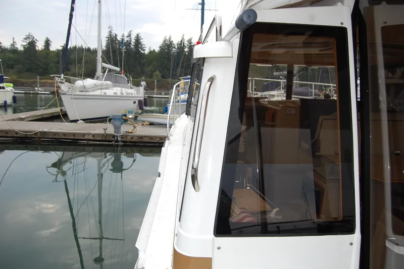 Slide: The Image of 2018 Ranger Tugs R29 docked at marina with sailboats in background. - 40