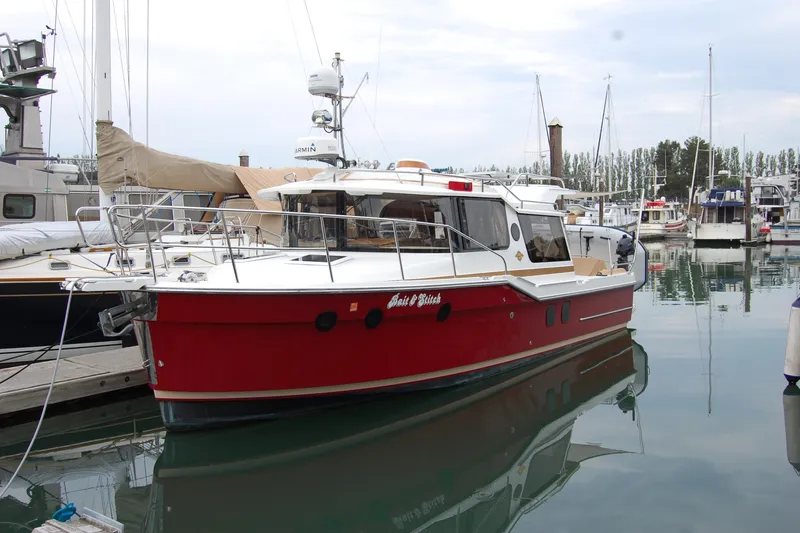 Slide: The Image of 2018 Ranger Tugs R29 boat docked in marina, featuring a striking red hull. - 45