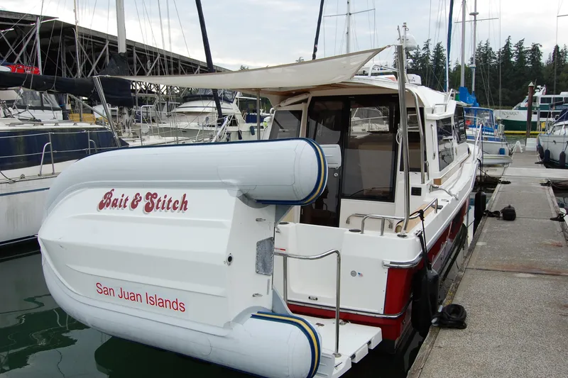 Slide: The Image of 2018 Ranger Tugs R29 docked at marina, featuring "Bait & Stitch" and San Juan Islands text. - 9