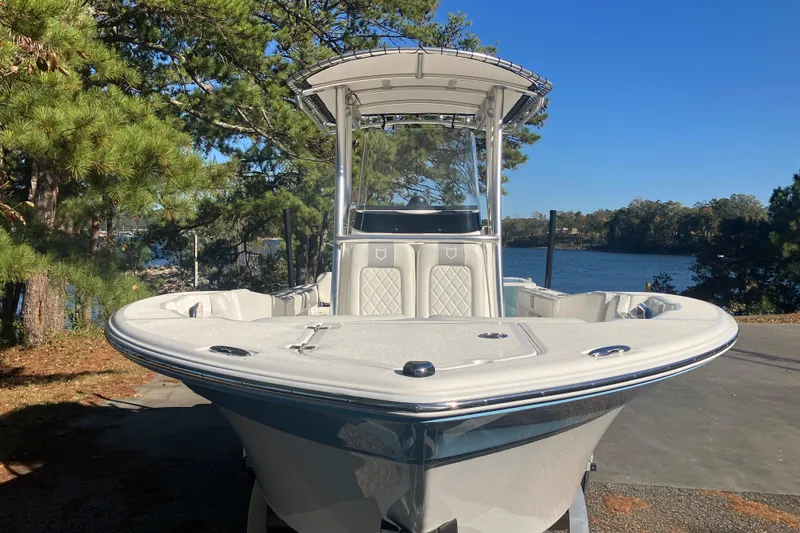 Slide: The Image of 2024 Sea Fox 248 Commander boat docked near a scenic lake with trees. - 2