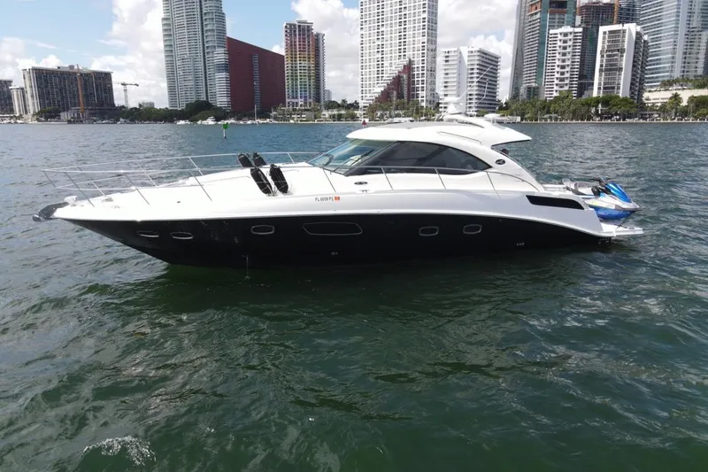 The Image of 2011 Sea Ray 470 Sundancer yacht on water with city skyline background. - 0