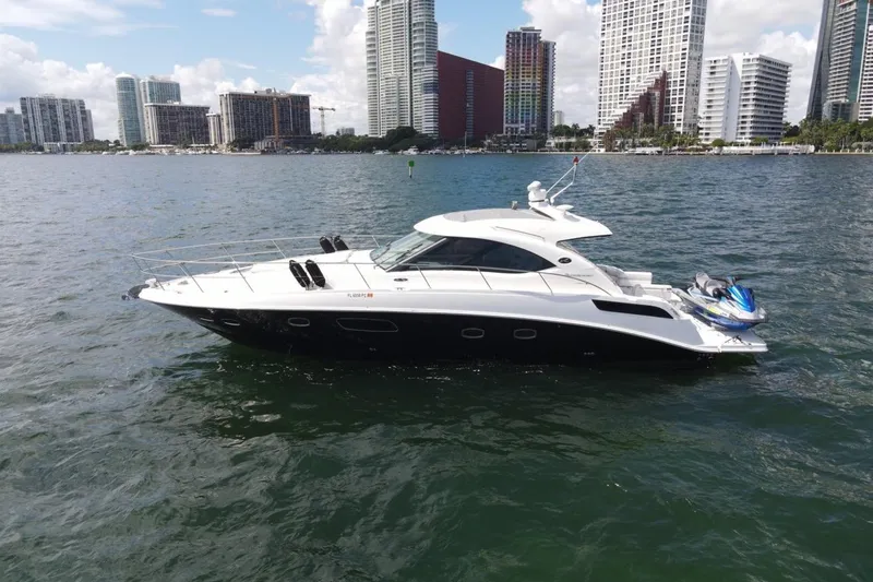 Slide: The Image of 2011 Sea Ray 470 Sundancer yacht on water with city skyline background. - 1