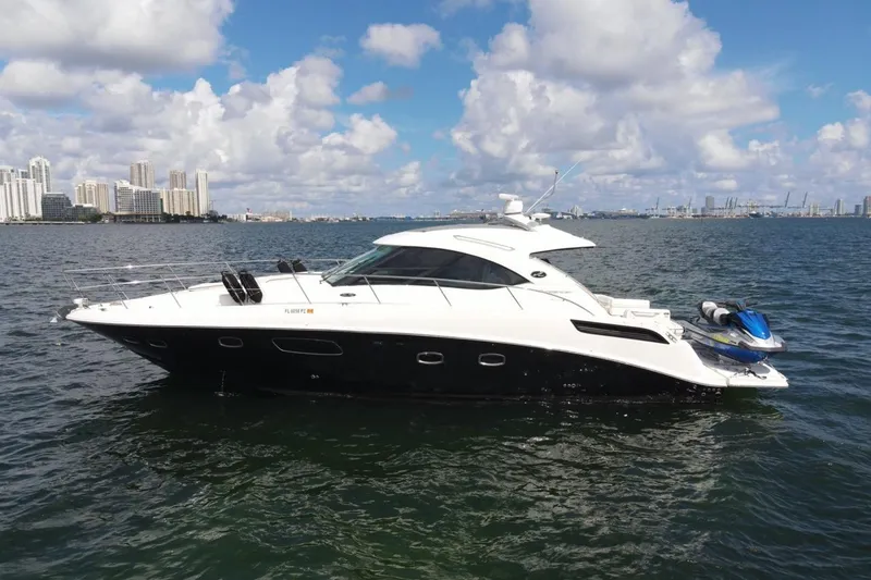 Slide: The Image of 2011 Sea Ray 470 Sundancer yacht on water with city skyline background. - 10