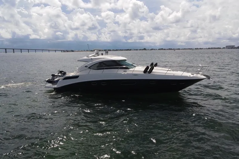 Slide: The Image of 2011 Sea Ray 470 Sundancer yacht cruising on open water under cloudy skies. - 16