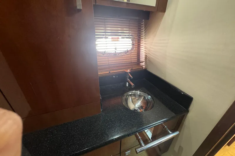 Slide: The Image of Luxurious 2011 Sea Ray 470 Sundancer yacht interior with sleek sink and wooden cabinetry. - 22