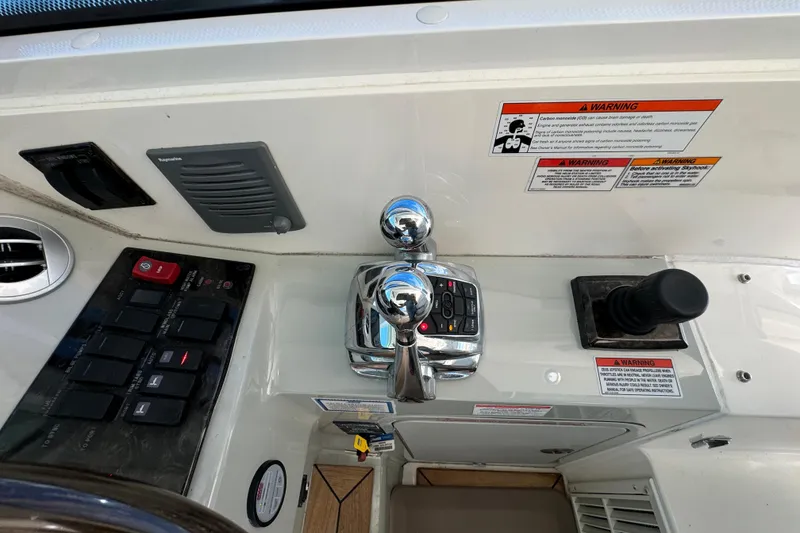Slide: The Image of Control panel of 2011 Sea Ray 470 Sundancer with throttle and joystick controls. - 44