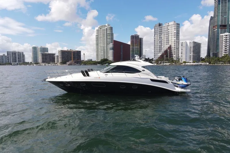 Slide: The Image of 2011 Sea Ray 470 Sundancer yacht on water with city skyline backdrop. - 6