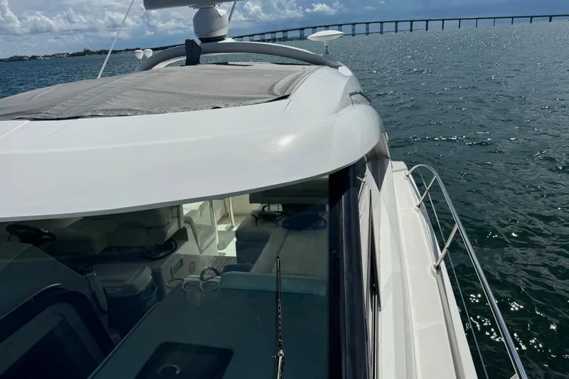 Slide: The Image of 2011 Sea Ray 470 Sundancer yacht cruising on open water with bridge in background. - 65