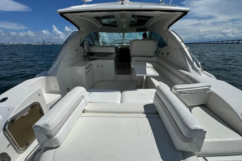 Slide: The Image of 2011 Sea Ray 470 Sundancer yacht interior with white seating, table, and ocean view. - 80
