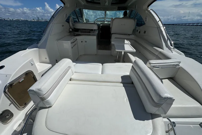 Slide: The Image of 2011 Sea Ray 470 Sundancer yacht interior with white seating and ocean view. - 81
