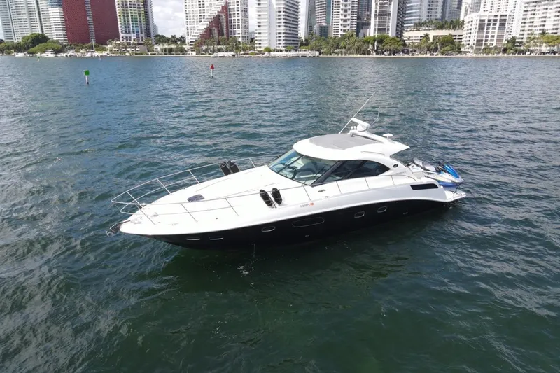 Slide: The Image of 2011 Sea Ray 470 Sundancer yacht cruising near city skyline on calm waters. - 9