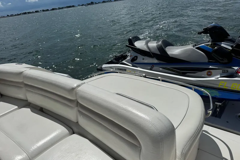 Slide: The Image of 2011 Sea Ray 470 Sundancer with Yamaha jet ski on water, featuring white seating. - 91