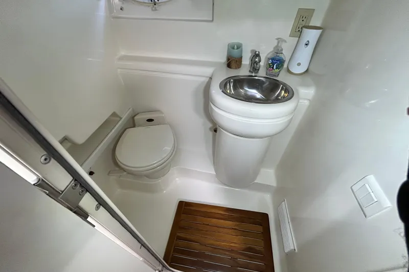 Slide: The Image of "Wet" head with shower, sink, and porthole window. - 26