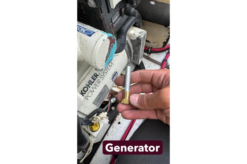 Slide: The Image of Hand holding a bolt near Kohler power system in 2000 Formula 31 Performance Cruiser. - 31