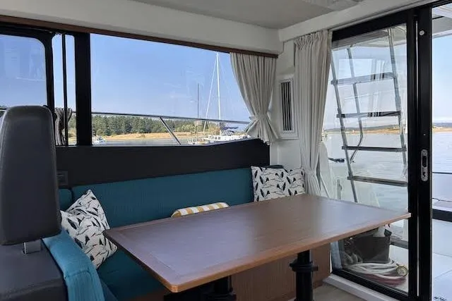 Slide: The Image of Interior of 2018 Jeanneau Velasco 37F yacht with dining area and scenic window view. - 11