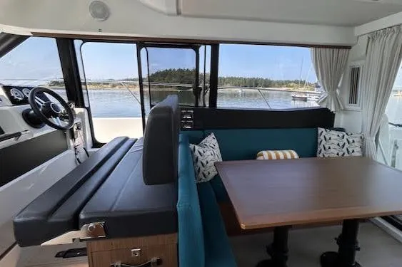 Slide: The Image of Interior of 2018 Jeanneau Velasco 37F yacht with seating and table, overlooking water. - 12