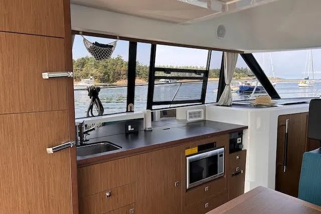 Slide: The Image of Interior of 2018 Jeanneau Velasco 37F yacht with modern kitchen and scenic window view. - 13