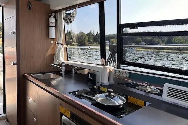 Slide: The Image of Interior view of 2018 Jeanneau Velasco 37F yacht kitchen with scenic water view. - 15