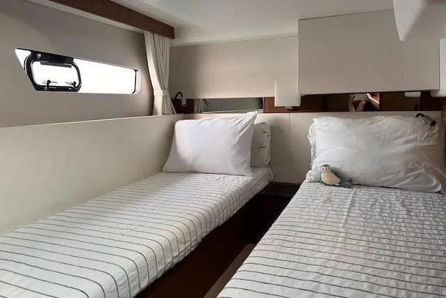 Slide: The Image of Interior cabin of 2018 Jeanneau Velasco 37F with twin beds and striped bedding. - 18