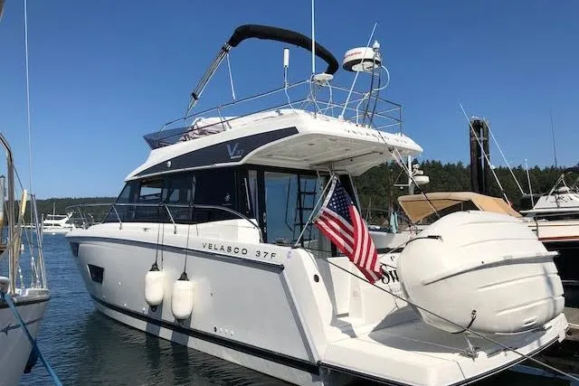 Slide: The Image of 2018 Jeanneau Velasco 37F yacht docked, featuring sleek design and American flag. - 2