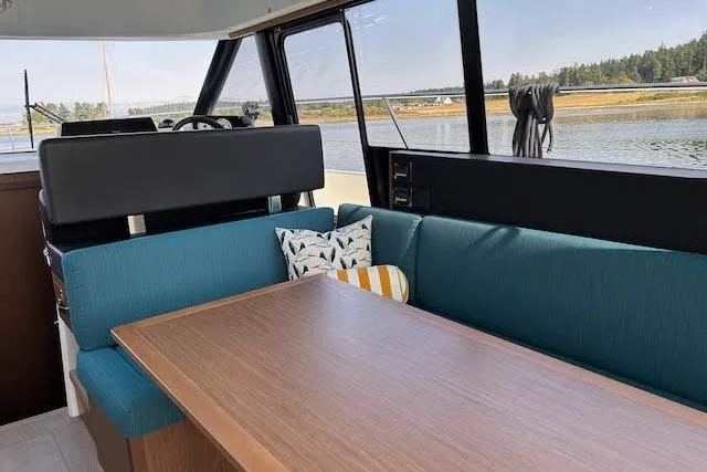Slide: The Image of Interior of 2018 Jeanneau Velasco 37F yacht with blue seating and wooden table. - 9