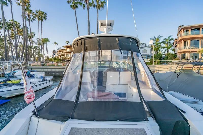 Slide: The Image of 2016 Sea Ray 370 Express Cruiser docked near palm trees and waterfront homes. - 10